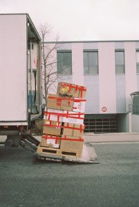 A pile of packed moving boxes being loaded on a moving truck