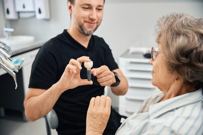 Woman,Examines,Model,Of,Dental,Implant,In,Hands,Of,Dental implants feel like real teeth